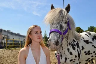 Lotte looking at her pony Sparrow in the arena